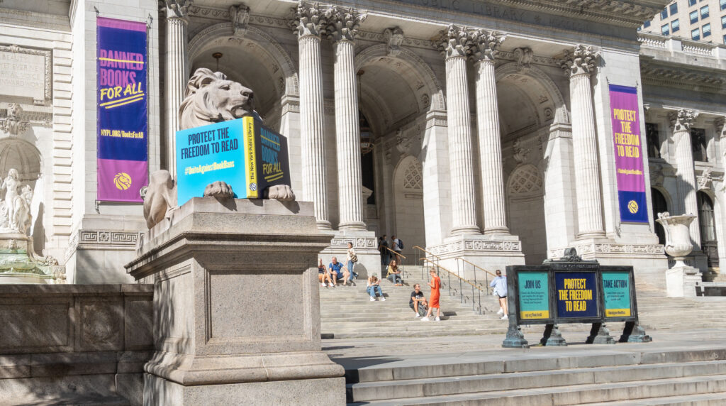 Photo of front facade of The New York Public Library. Large banners read "BOOKS FOR ALL" AND "PROTECT THE FREEDOM TO READ"