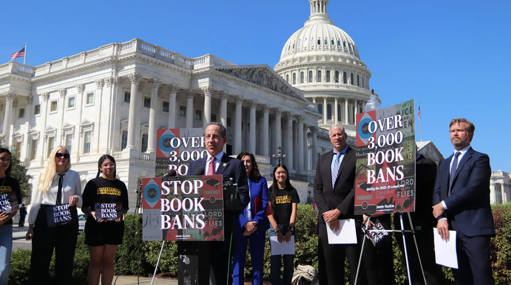 Photo of Democratic House representative Jamie Raskin speaking among a group of advocates in front of the capitol building. Sings read STOP BOOK BANS nd OVER 3,000 BOOK BANS.