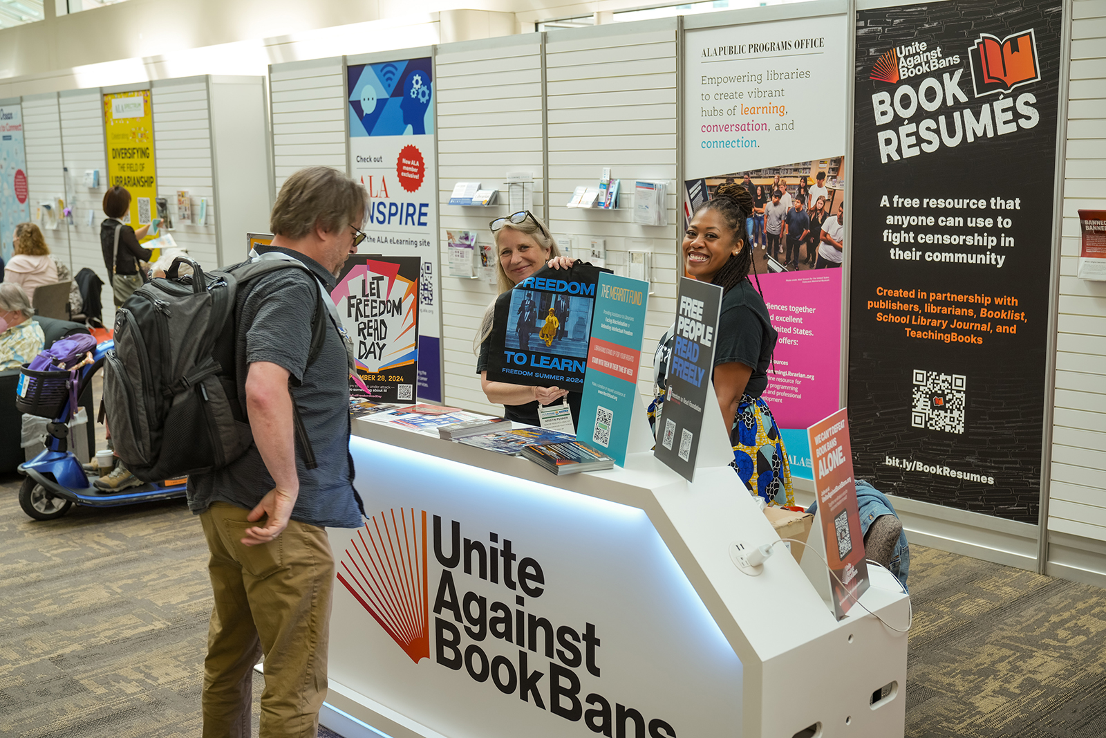 A conference attendee visits the Unite Against Book Bans booth.