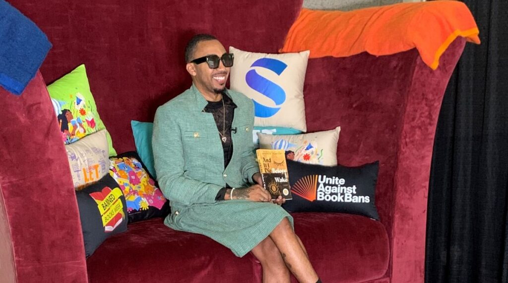 Bestselling, award winning, and frequently banned author George M. Johnson reads from his forthcoming memoir, And If I Die Before I Wake (Farrar, Straus and Giroux (BYR)), in the Big Chair at ALA in Chicago. Photo credit: Sage